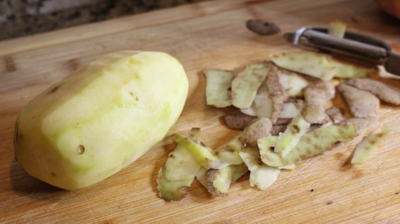 peeled russet potato and peel on cutting board