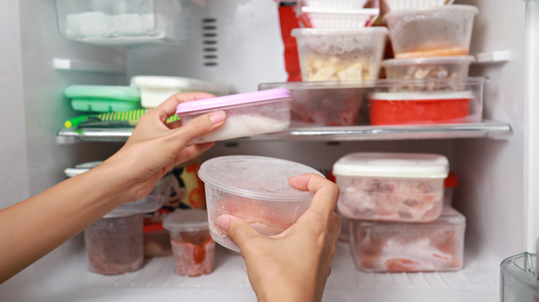 Person adding containers to freezer