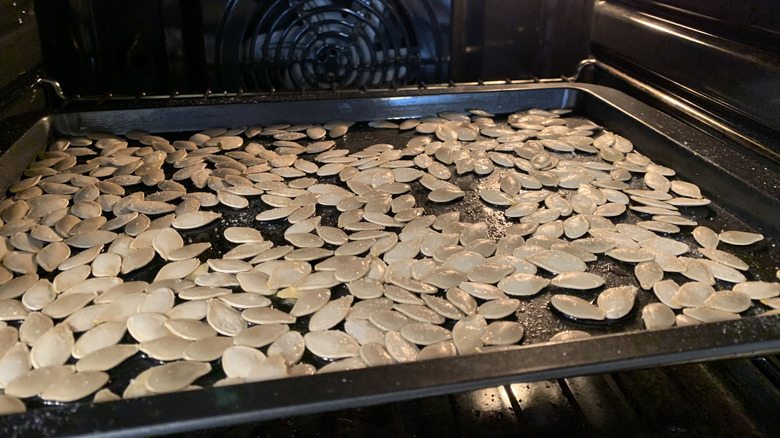 pumpkin seeds on tray in the oven