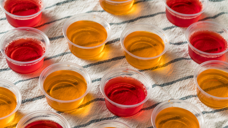 Red and orange Jell-O shots sit on a striped cloth