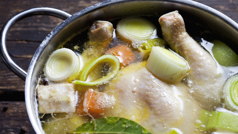 Pot with brother, whole chicken, and vegetables