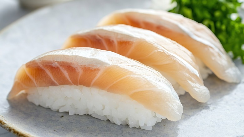 Three slices of yellowtail sushi on a plate