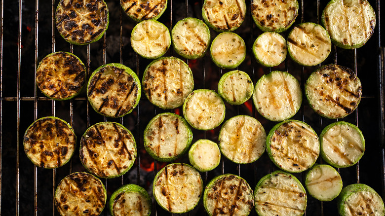 Charred pieces of zucchini on a grill