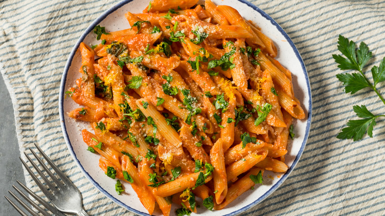 Penne alla vodka on a plate garnished with herbs