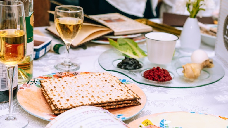 Jewish Passover dinner table with matzo, seder plate, wine