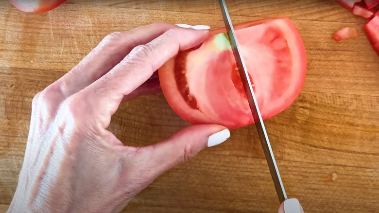 Cutting halved tomato into wedges