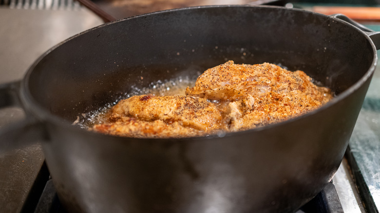 A heavy pot frying chicken on the stove