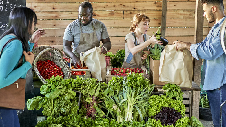 Vendors selling vegetables at farmers market