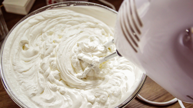 Top view of a mixer whipping a bowl of cream