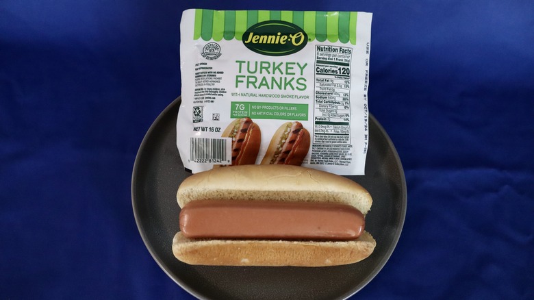 turkey hot dog in bun on plate next to package