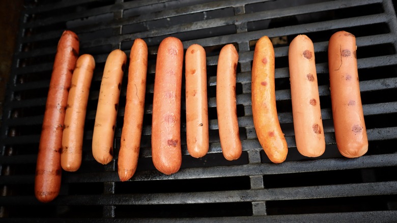 variety of hot dogs on grill