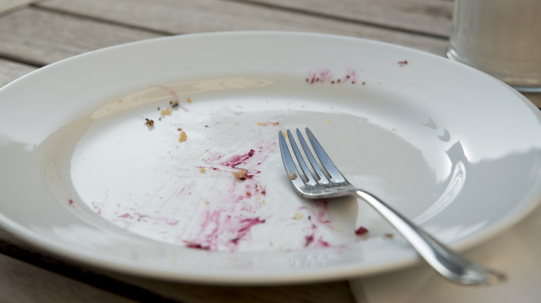 A fork in the 4 o'clock position on an empty plate.