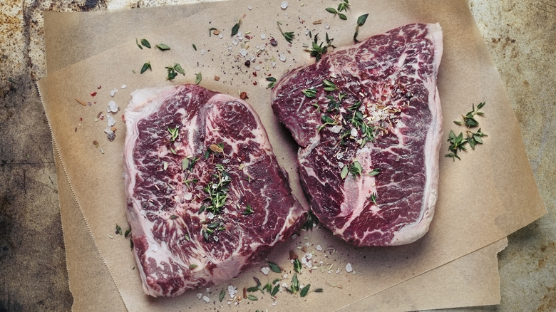 Seasoned raw steaks on butcher paper