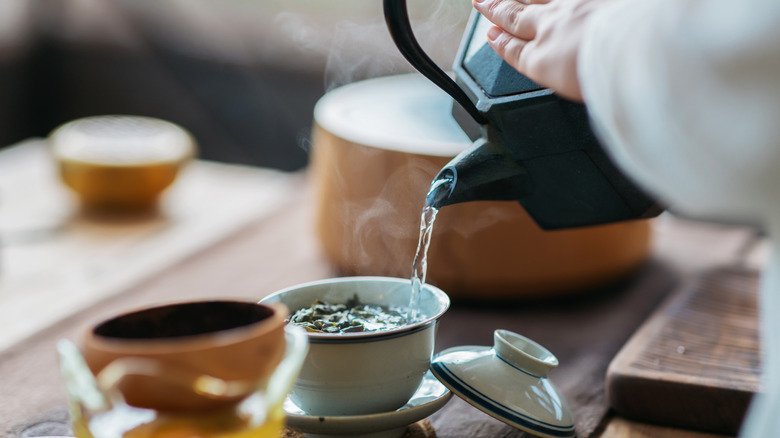 pouring water over tea leaves