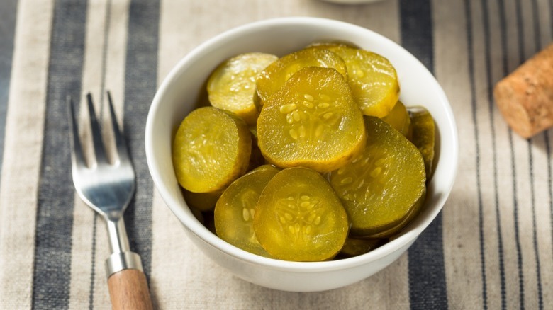 Bowl of bread and butter pickles on a striped tablecloth