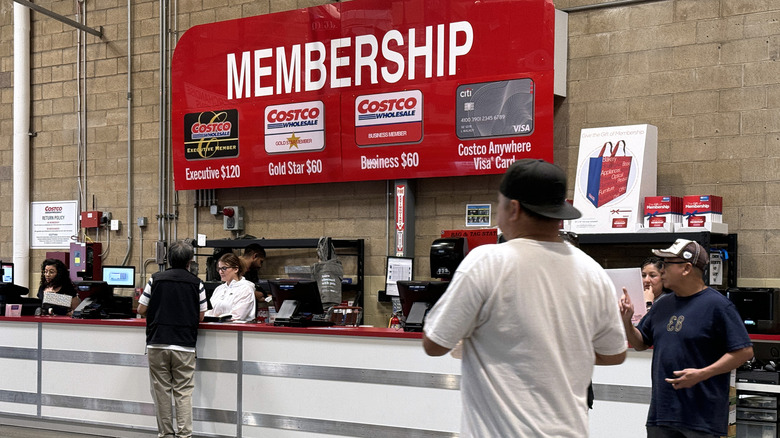 Members stand at the Membership kiosk inside a Costco