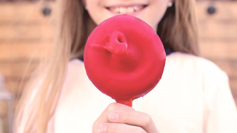 A little girl holds a cherry-coated Dilly Bar