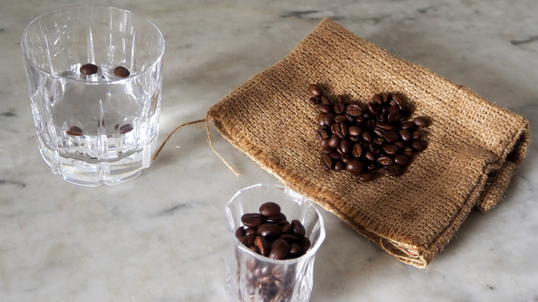 Glass of sambuca next to coffee beans