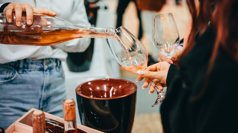 A sommelier pouring wine for a walk-around tasting.