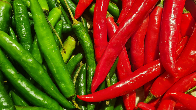 A close up on a bunch of red and green chiles sitting side by side