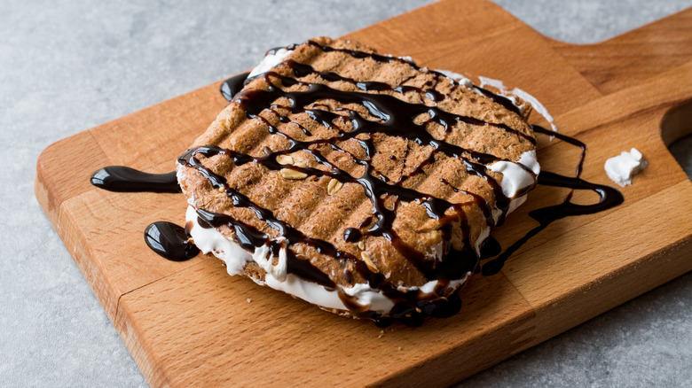 Fluffernutter sandwich with chocolate drizzle on wooden board