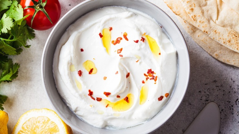 Whipped feta dip in a bowl topped with pepper flakes and olive oil 