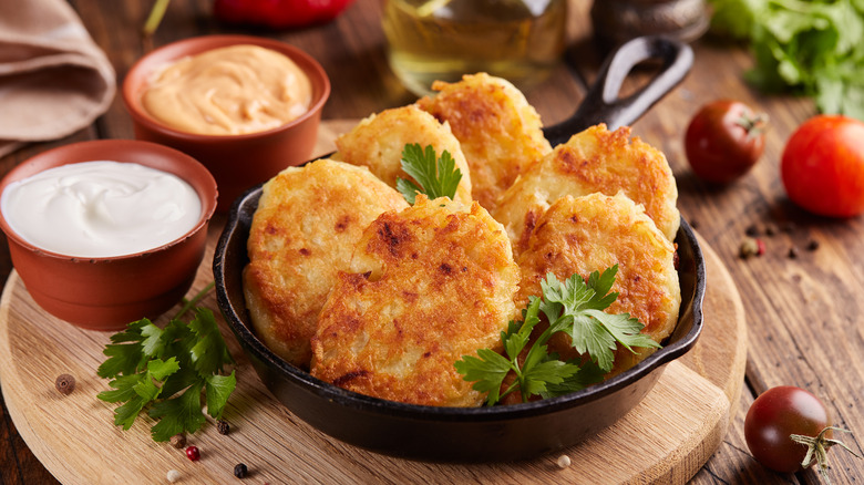 Crispy hash browns in pan with dips