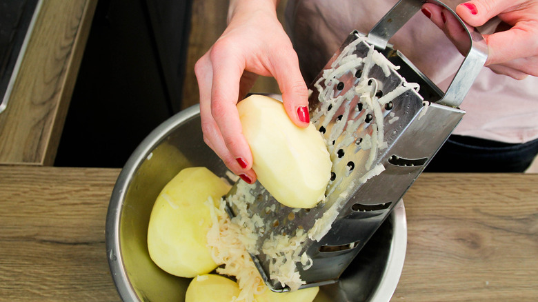 Person grating potato for hash browns