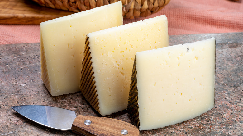 Pieces of Manchego and Iberico cheese with cheese knife