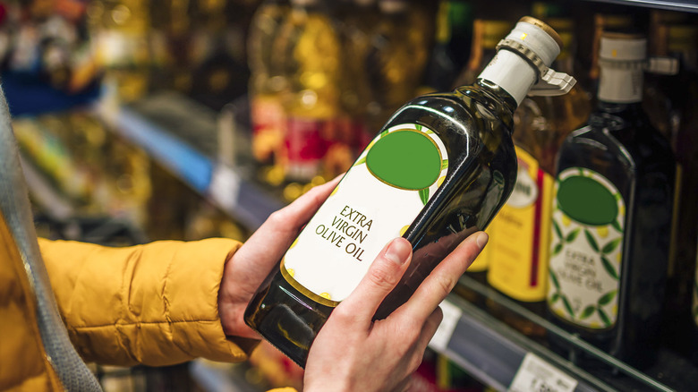 holding olive oil bottle
