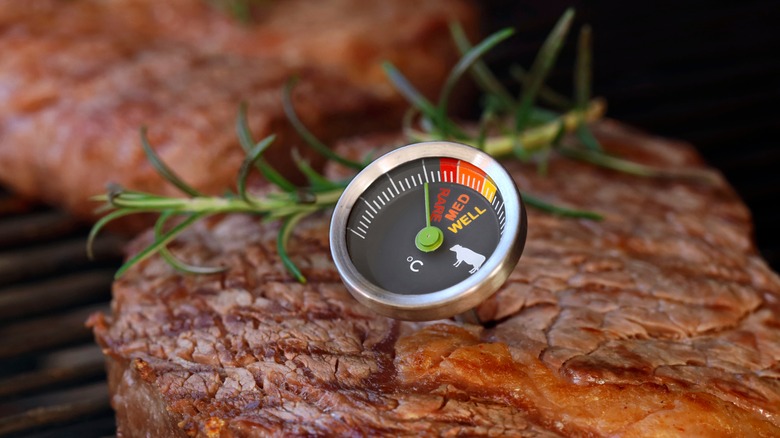 Two steaks with rosemary and thermometer