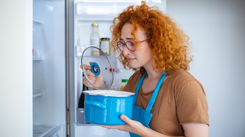 Women smelling pot in front of fridge