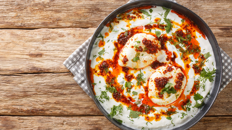 Turkish style eggs with chili crisp, yogurt and fresh herbs