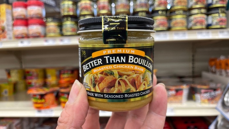 a hand holding a jar of better than bouillon