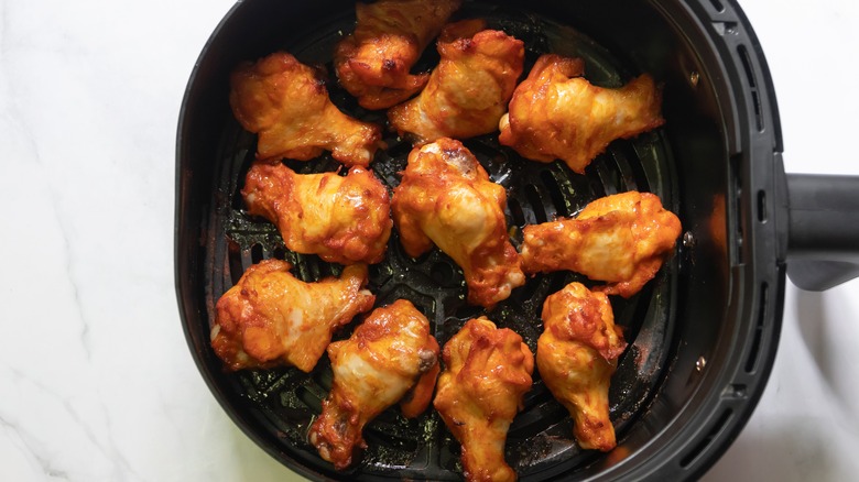 Cooked chicken wings in air fryer basket