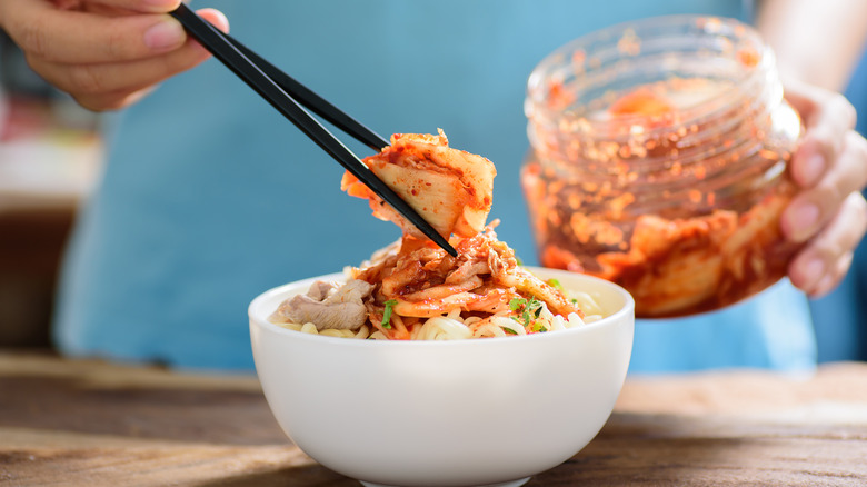 Person removing kimchi from a jar