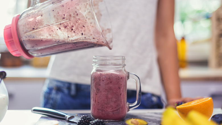 Pouring smoothie into a mason jar