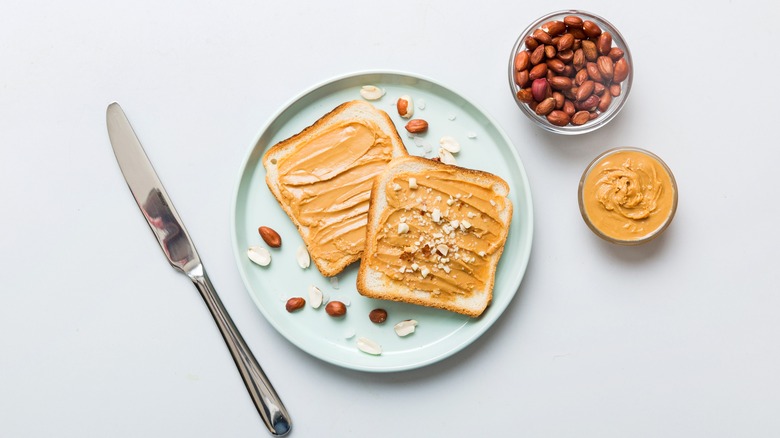 peanut butter spread on bread next to knife