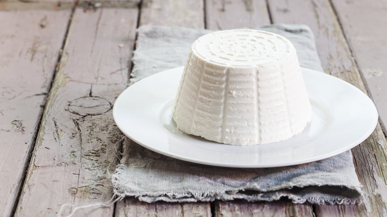 A plate of ricotta on a wooden board