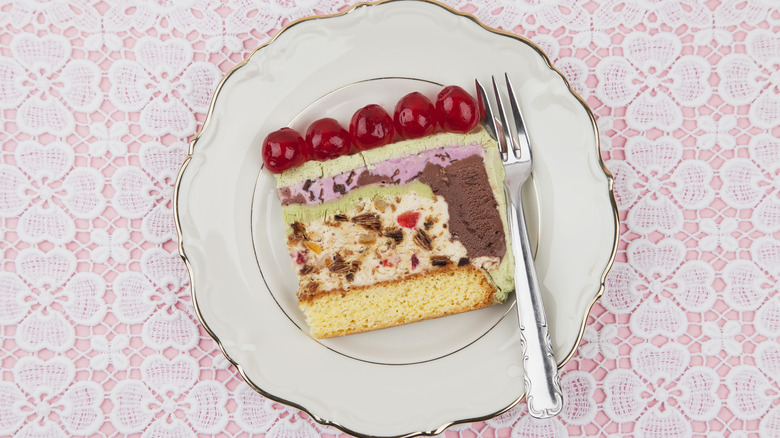 Slice of ice cream cake on plate with fork