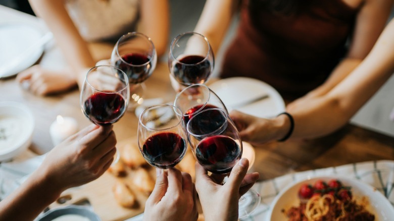 Group of people toasting with red wine