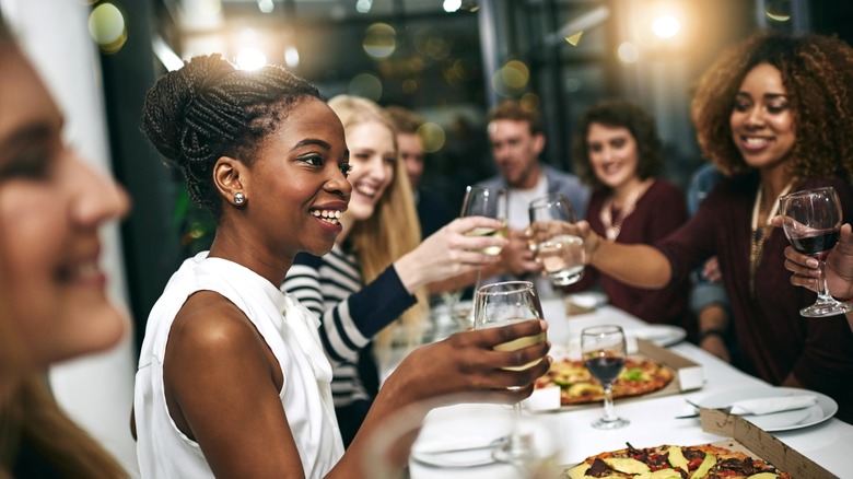 Guests eating pizza and drinking wine