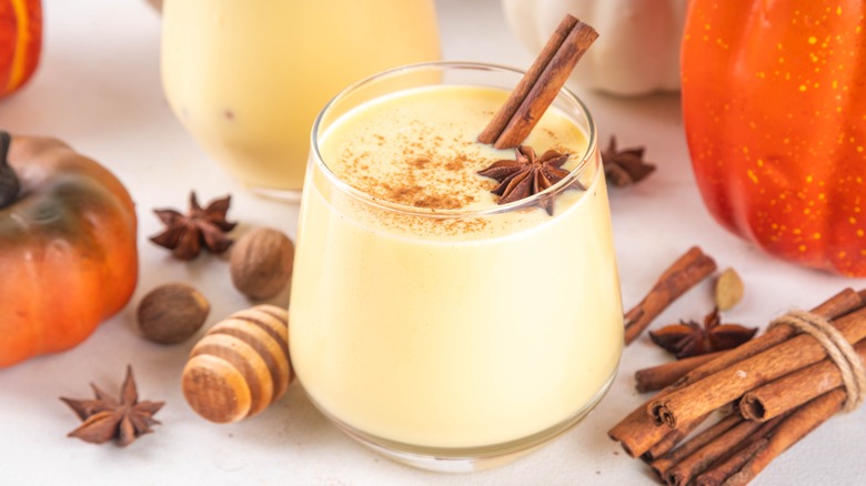 Eggnog holiday drink in a round tumbler with star anise and cinnamon stick garnish