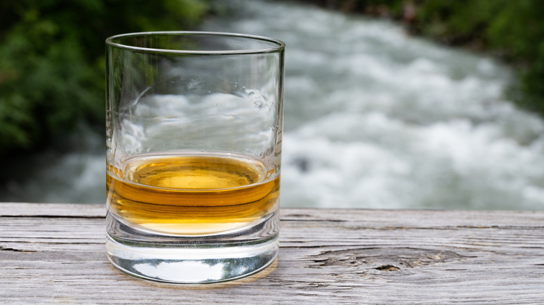 single malt whisky in glass with river in background