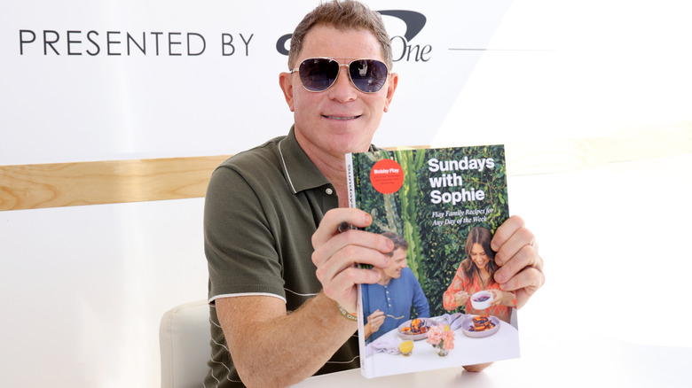 Bobby Flay holding one of his books
