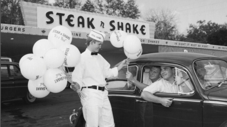 Steak 'n Shake worker holding balloons.