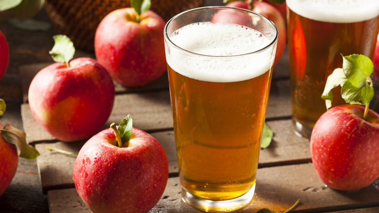 Glass of hard apple cider with apples