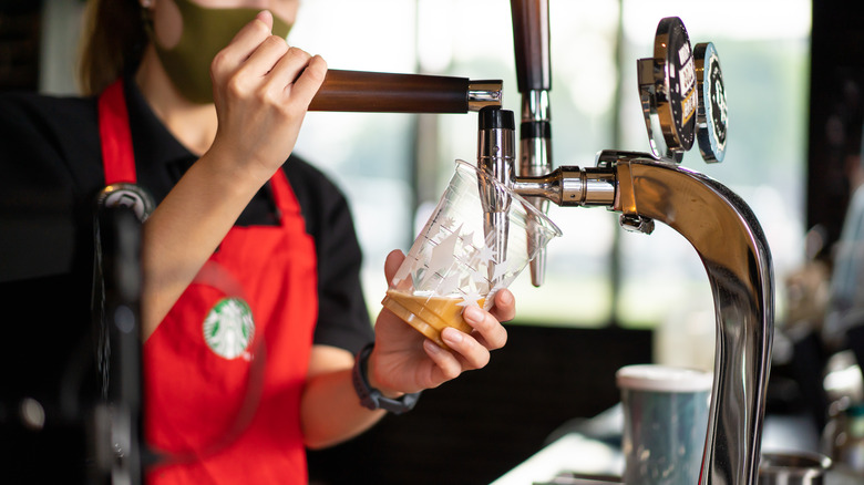 Starbucks barista pours coffee from tap