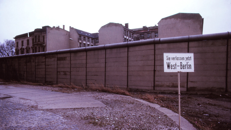 Gray photo of Berlin Wall with sign in German