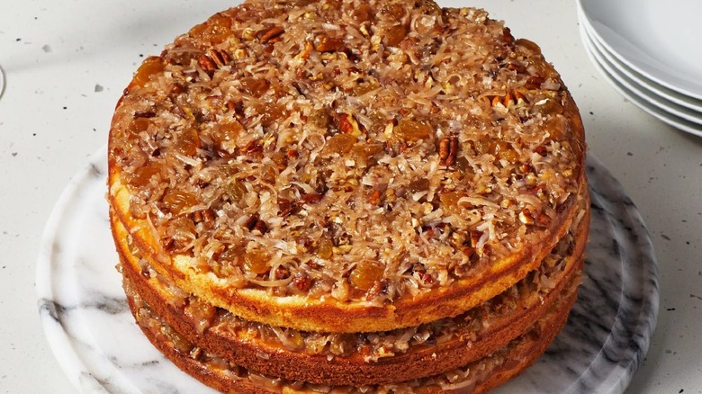 Lane cake with traditional pecan topping on white marbled plate